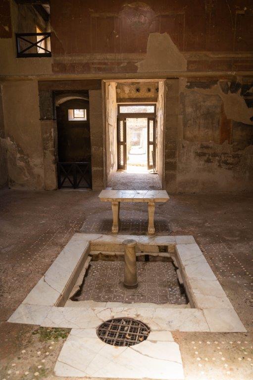 Atrio de la Casa del Tramezzo di Legno: impluvium de mármol y decoración arquitectónica romana