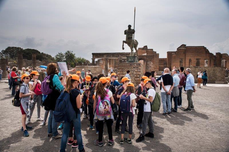 Zona excavada de Pompeya con visitantes recorriendo las calles de la antigua ciudad romana